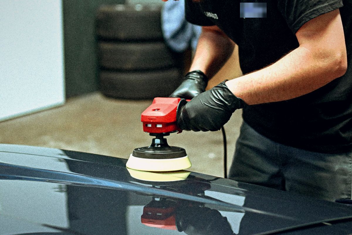 Travail de finition sur la carrosserie d'une voiture