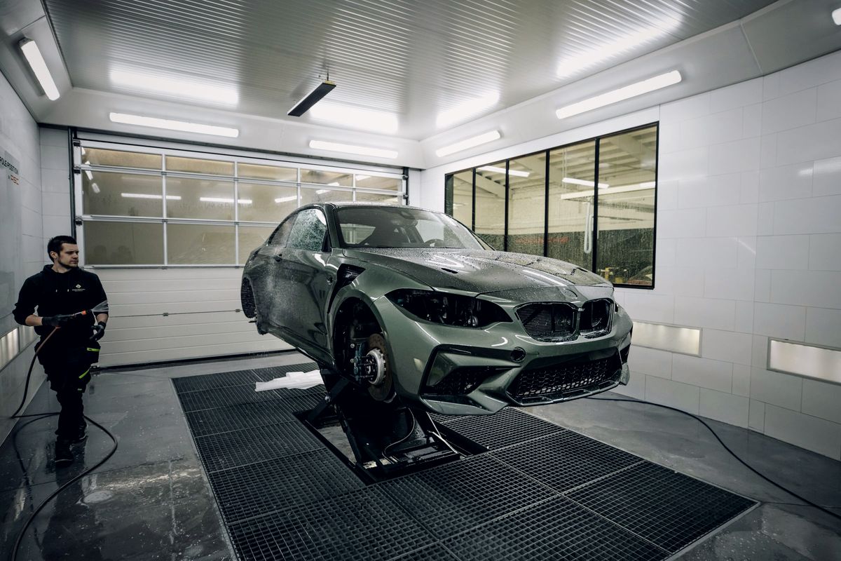 Voiture en préparation dans un box d'atelier