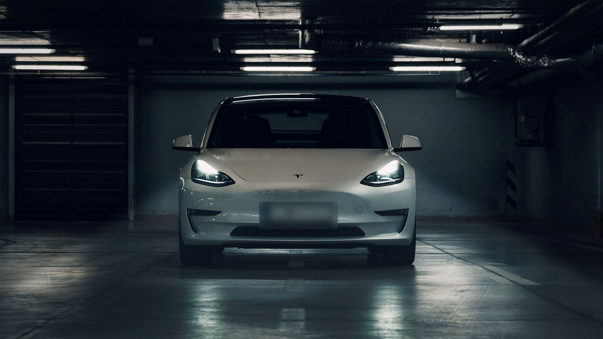 Voiture prête à la livraison, phares allumés, dans le hall du garage