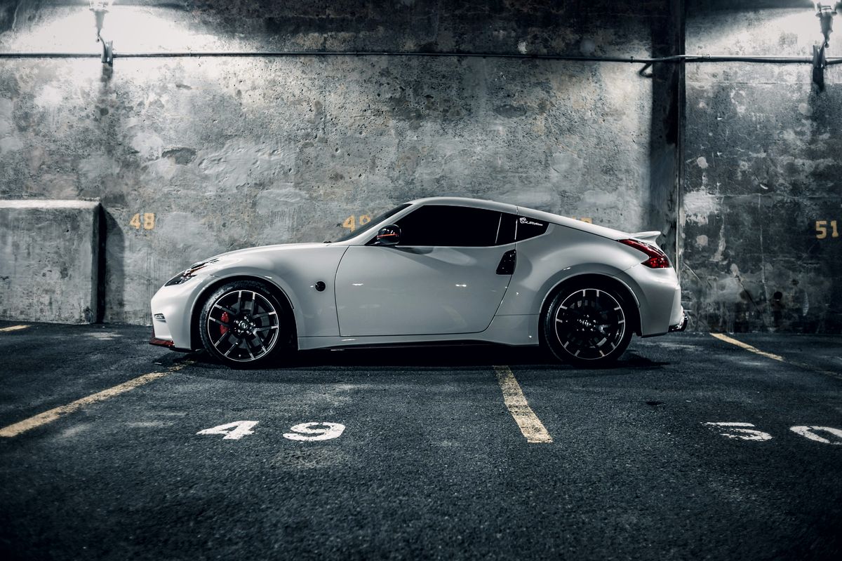 Coupé sportif blanc garé dans un parking en béton