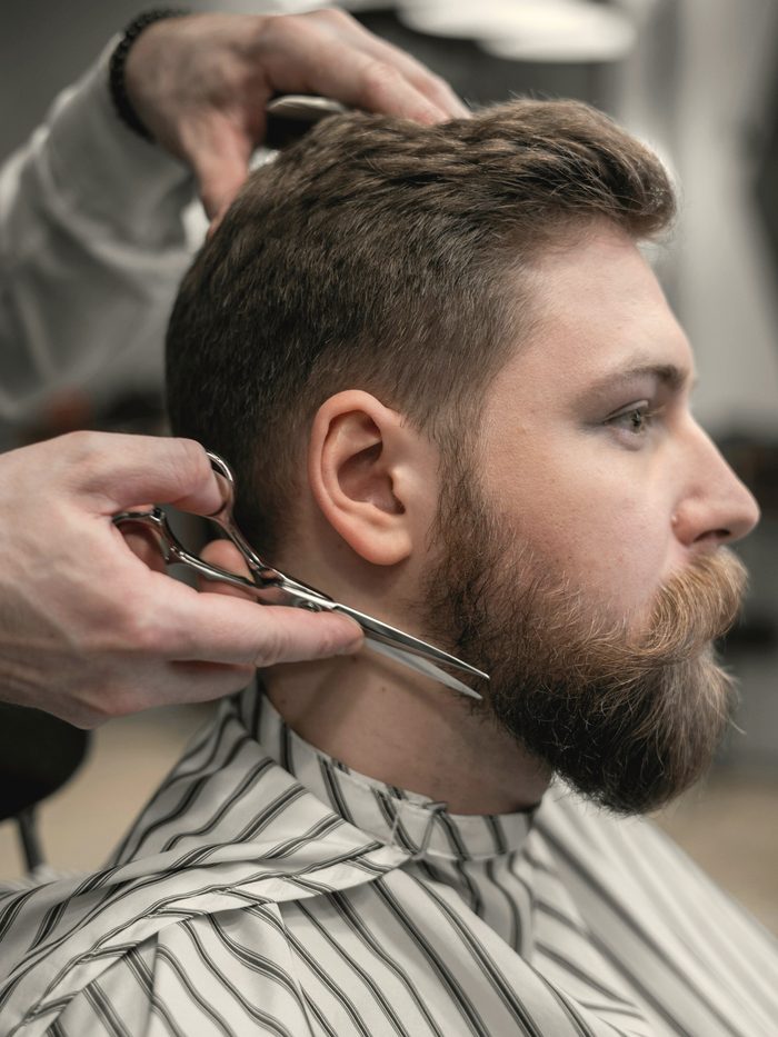 Nuno, barbier, taille une barbe aux ciseaux